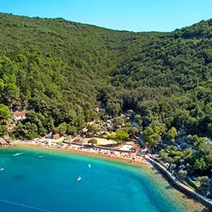 "Panoramski pogled na Kamp Zdovica na Cresu uz šljunčanu plažu i zeleno mediteransko okruženje"